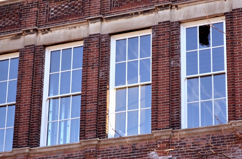 Windows in an old building, one if the windows has a broken pane