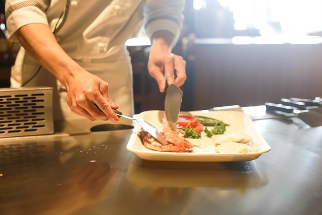 A chef building a plate in an organized kitchen.